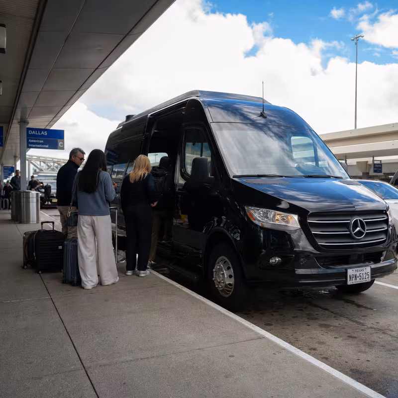 Group boarding a white charter bus for Airport Transportation transportation in Dallas
