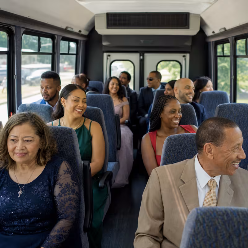 Group boarding a white charter bus for Private Event Transportation transportation in Dallas