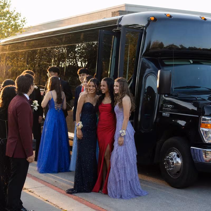 Group boarding a white charter bus for Prom & Homecoming Transportation transportation in Dallas