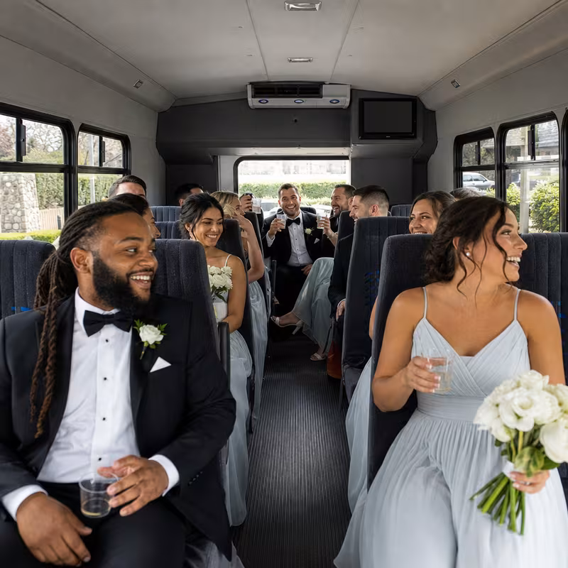 Group boarding a white charter bus for Wedding Transportation transportation in Dallas